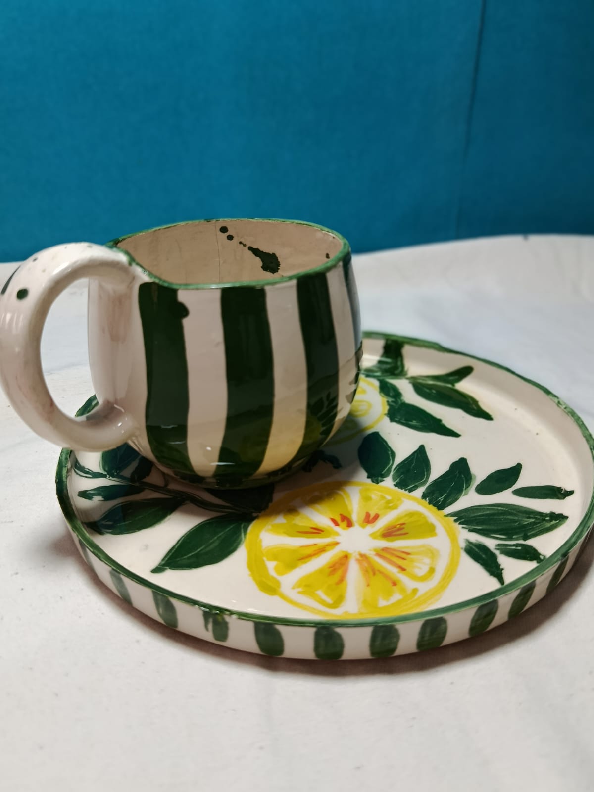 Taza rayada con plato de limones